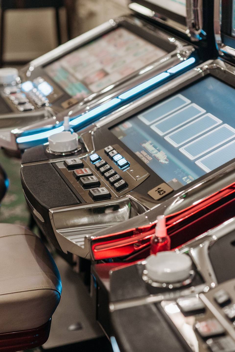 Painel de uma slot num casino: ecrãs, botões de aposta e o botão de girar